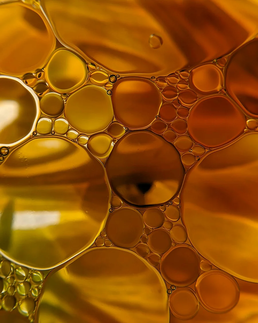 Golden oil drops in water, close-up